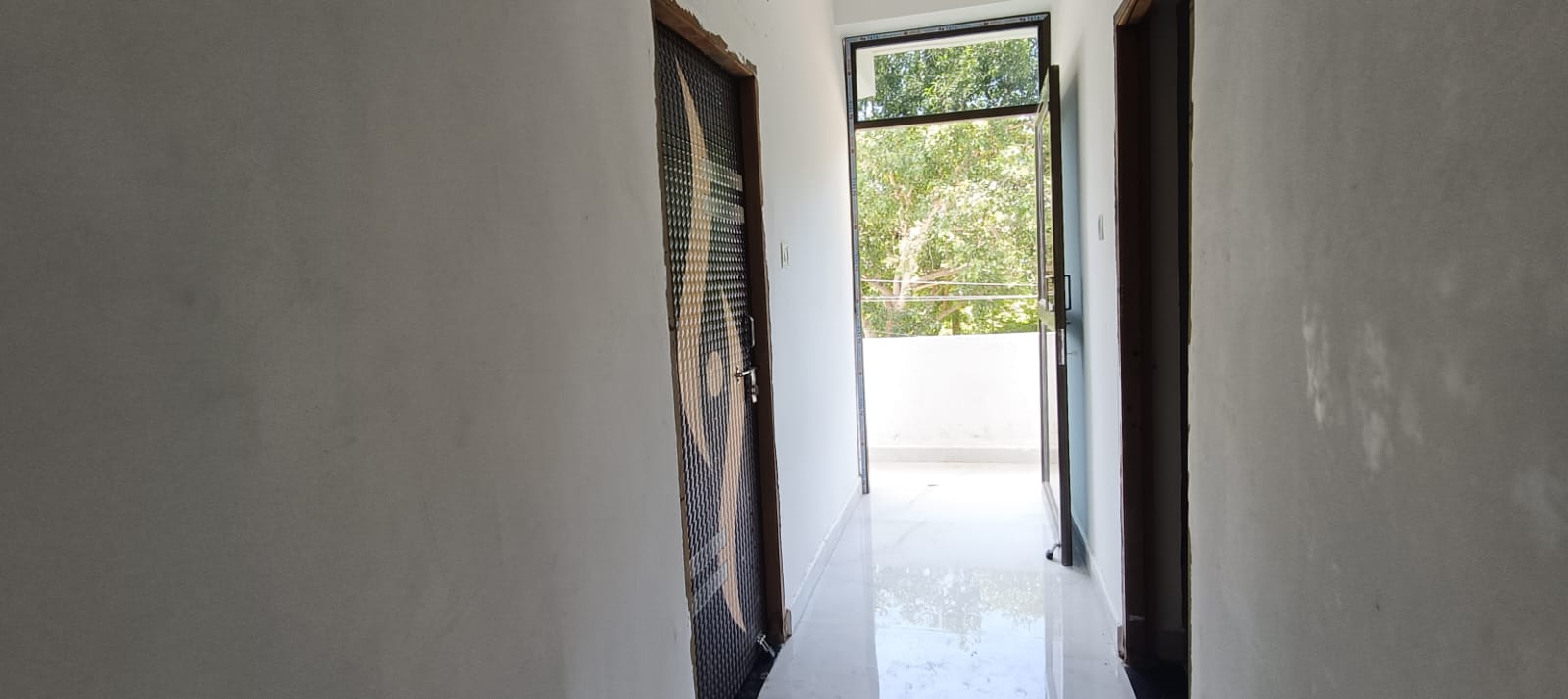 A bright hallway leading out to a balcony at Anup House
